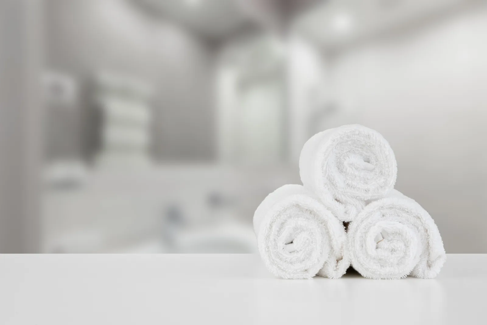 Serviettes blanches roulées dans une salle de bain propre et lumineuse